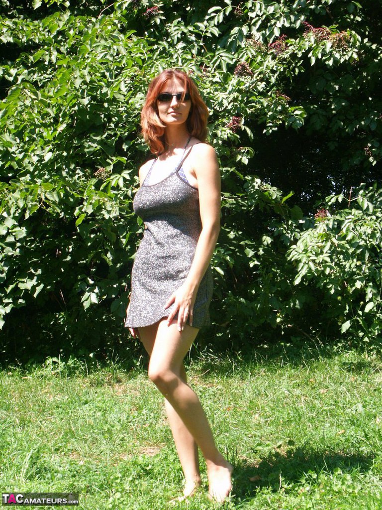 Hot redhead amateur Vanessa disrobes under a tree to air her big saggy tits   